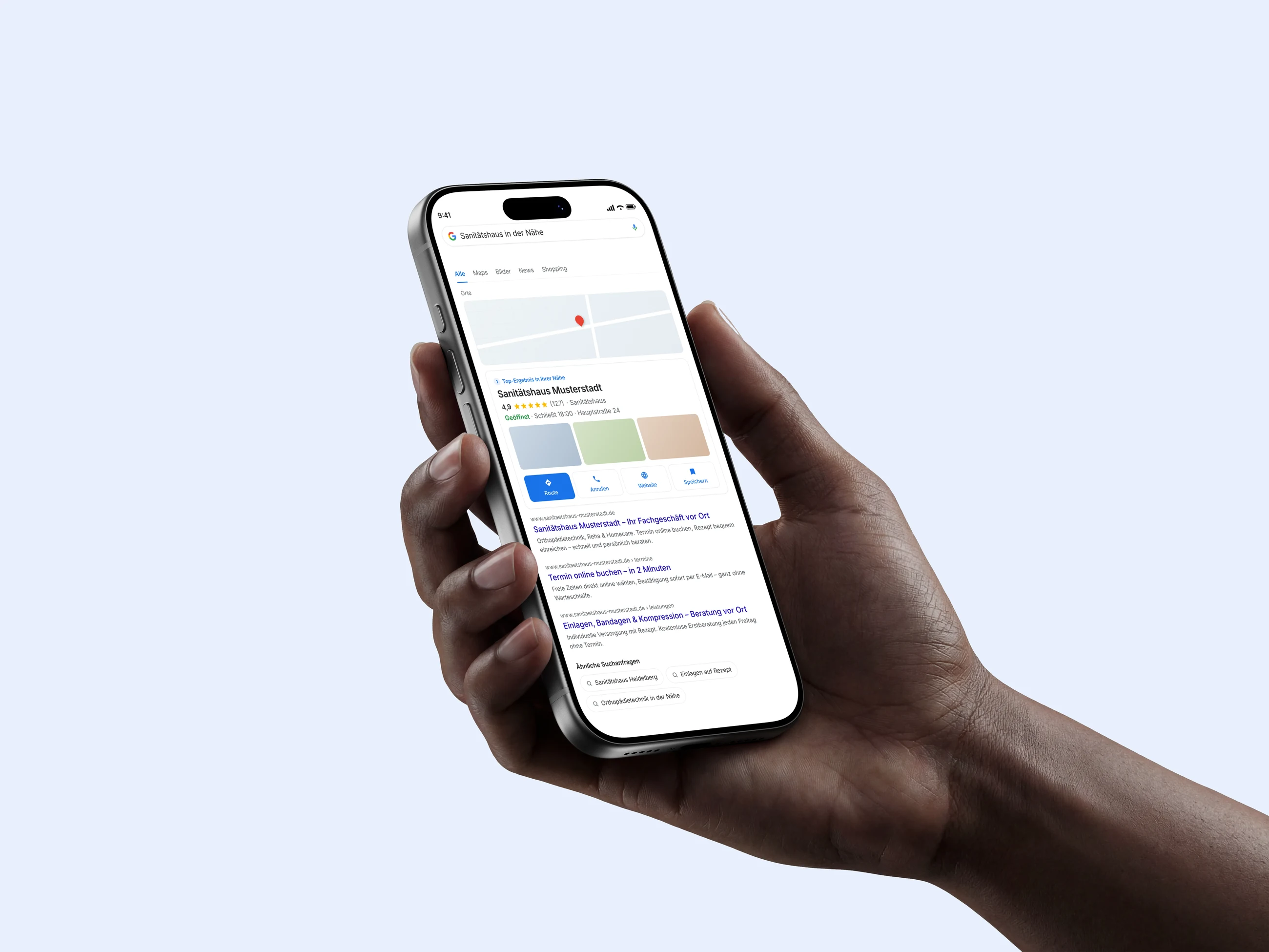 Hand hält ein iPhone mit Google-Suche: Firma mit gepflegtem Google-Unternehmensprofil in den lokalen Treffern